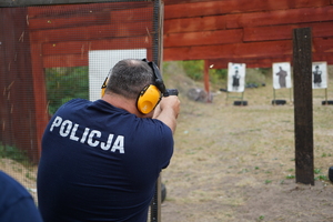 policjanci biegną przez przeszkody i strzelają z pistoletów do tarcz na strzelnicy