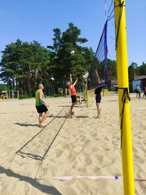 uczestnicy grają w siatkówkę plażową