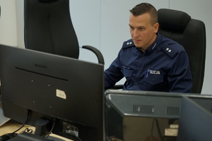policjant siedzi przed monitorem