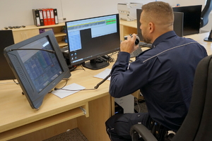 policjant siedzi przed monitorem