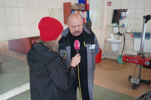 pracownik stacji obsługi pojazdów rozmawia z dziennikarzami