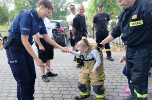 Policjantka wręcza dziewczynce nagrodę za odwagę