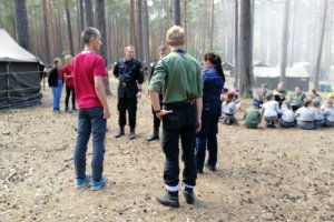 Funkcjonariusze rozmawiają z komendantami obozowiska o podstawowych zasadach związanych z bezpieczeństwem