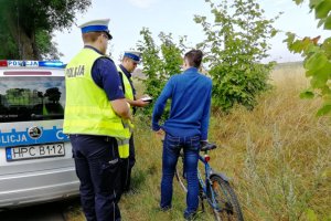 Policjanci pouczają kierowcę roweru za popełnione wykroczenie