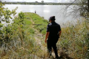 Policjantka sprawdza bezpieczeństwo osób łowiących ryby nad Wisłą