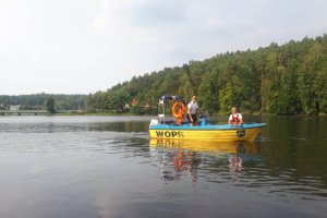 Policjant i funkcjonariusze WOPRu patrolujący teren Zalewu Żurskiego