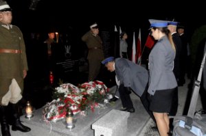 Delegacja policji i straży pożarnej składa kwiaty na mogile żołnierzy