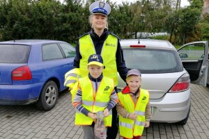 Dzieci z założonymi kamizelkami w obecności policjantki