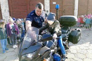 Chłopiec siedzi za kierownicą motocykla