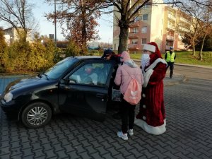 mikołaj podchodzi do samochodu wręczyć nagrodę kierowcy