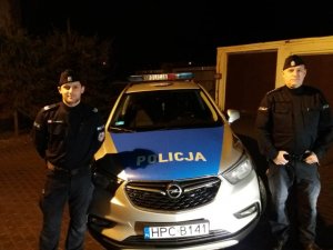 policjanci stojący przy radiowozie