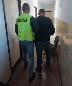 zatrzymany mężczyzna prowadzony przez policjanta