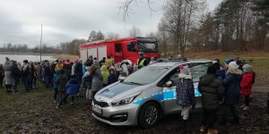 policjant ruchu drogowego przedstawia dzieciom zasady bezpieczeństwa w ruchu drogowym