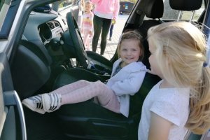 Dziewczynki siedzą za kierownicą radiowozu