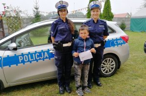 Policjantki ruchu drogowego pozują do zdjęcia z chłopcem