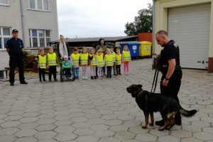 Policjant prezentuje umiejętności psa służbowego