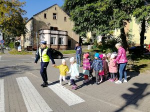 Policjantka przeprowadza dzieci przez jezdnię