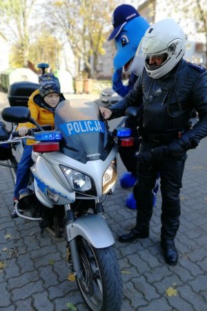 Kubuś siedzi za kierownicą policyjnego motocykla
