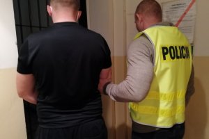 Policjant prowadzi zatrzymanego