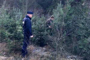 Policjant wraz ze strażnikiem leśnym wchodzą do lasu