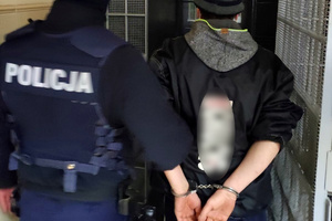 Policjant wprowadza zatrzymanego do celi