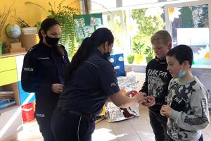 Policjantki podają dzieciom piłeczki