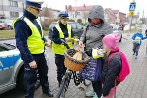 Mundurowi rozmawiają z  kobietą i jej wnuczka o bezpieczeństwie pieszych oraz wręczają ulotki