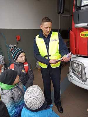 Policjant pokazuje dzieciom książeczkę