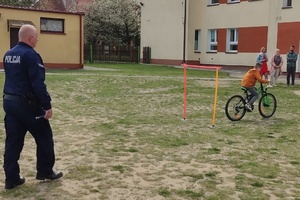 Policjant kontroluje umiejętności praktyczne jazdy na rowerze