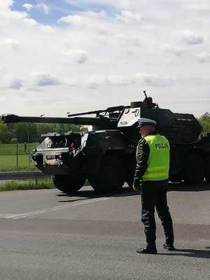 Policjant ruchu drogowego, a tle czołg