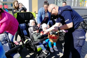 Policjant podaje rękę maluszkowi