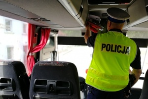Policjant kontroluje wyposażenie autokaru