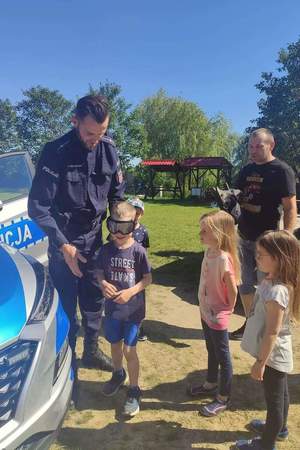 Policjant prowadzi zabawy z dziećmi przy użyciu alkogogli