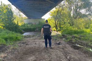 Policjant stoi pod mostem w rejonie Wisły