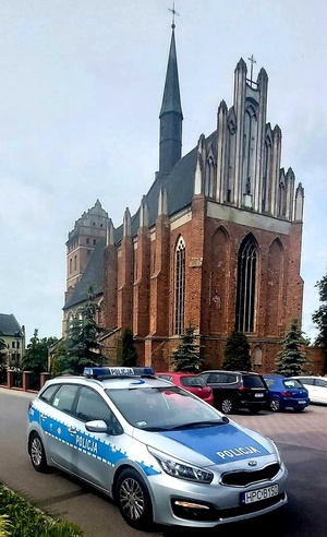 Radiowóz na tle kościoła parafialnego
