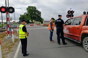 Mundurowi udzielają instruktarzu kierowcy, który zatrzymał samochód zbyt blisko szlabanu