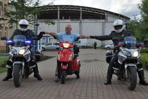 Policjanci na motocyklach wspólnie pozują do zdjęcia z organizatorem biegu