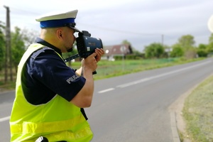 Policjant ruchu drogowego mierzy prędkość pojazdów