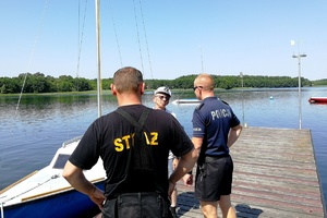 Policjant i strażak rozmawiają z mężczyzną na pomoście