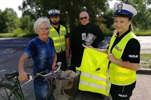 Do zdjęcia pozuje rowerzystka w towarzystwie policjantów i Kapelana Policji