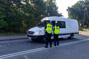 Funkcjonariusze rozmawiają z kierowcą busa