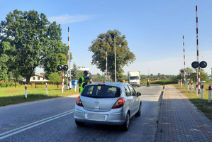 Policjantka ruchu drogowego rozmawia z kierowcą przy przejeździe kolejowym