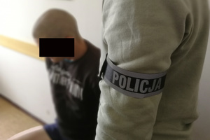 Zatrzymany sprawca kradzieży rowerów pilnowany przez policjanta