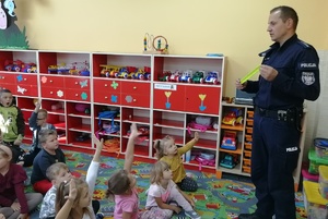 Policjant pokazuje dzieciom działanie odblasku