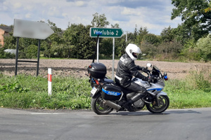 Policjant na motocyklu zawraca na skrzyżowaniu