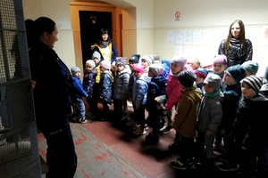 Policjantka prezentuje dzieciom pomieszczenie dla osób zatrzymanych