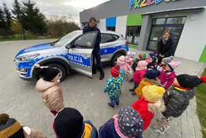 Policjant prezentuje przedszkolakom radiowóz