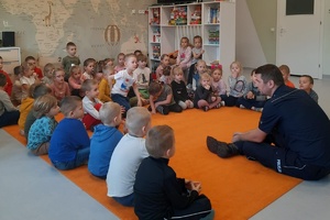 Policjant prowadzi rozmowę z dziećmi