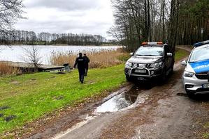 Mundurowi idą w kierunku jeziora i patrolują teren przywodny