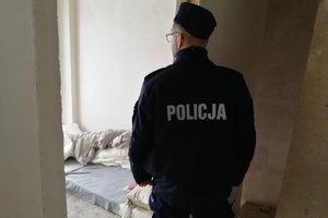 Policjant spogląda do pomieszczenia, w którym mogli przebywać bezdomni